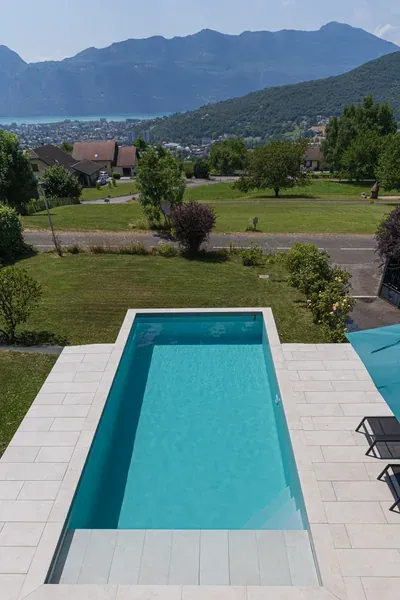 Vue plongeante sur une piscine dans un jardin dominant la vallée, à Grésy-sur-Aix