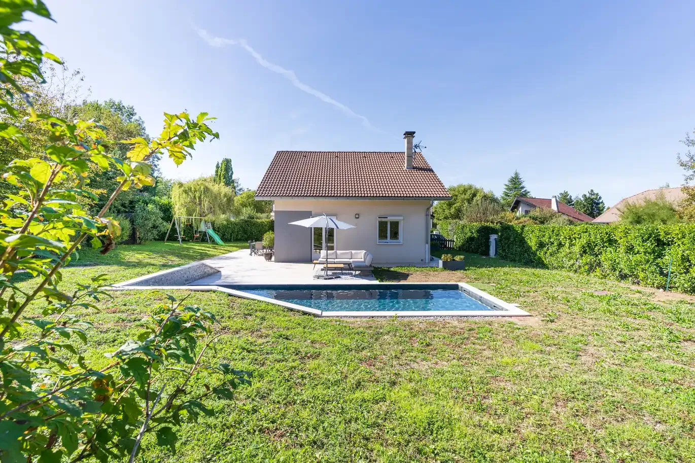 Piscine rectangulaire bordée d’une terrasse en bois à Annecy