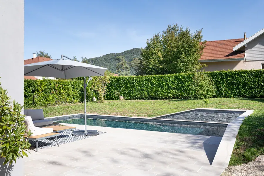 Piscine bordée d’une haie taillée face aux montagnes à Annecy